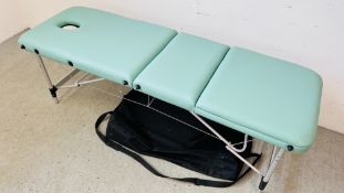A FOLDING FAUX LEATHER MASSAGE BED IN CARRY CASE.