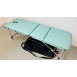 A FOLDING FAUX LEATHER MASSAGE BED IN CARRY CASE.