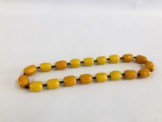 A LARGE AMBER TYPE NECKLACE 74CM.