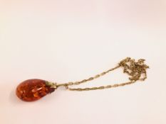 A 9CT GOLD CHAIN L 60CM SUPPORTING AN AMBER TYPE PENDANT INAA 9CT GOLD MOUNT L 5.5CM.