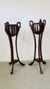 A PAIR OF HARD WOOD AND CARVED JARDINIERE STANDS WITH BASKET TOPS - HEIGHT 130 CM. A/F.