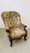 AN ANTIQUE CARVED HARDWOOD BUTTON BACK ARMCHAIR.