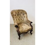 AN ANTIQUE CARVED HARDWOOD BUTTON BACK ARMCHAIR.