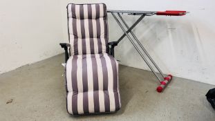 A FOLDING SUN CHAIR WITH CUSHIONS AND IRONING BOARD.