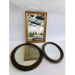 A GILT FRAMED MIRROR ALONG WITH TWO OVAL HARDWOOD EXAMPLES.
