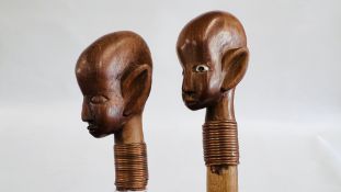 TWO ETHNIC CARVED WALKING CANES WITH COILED COPPER DETAIL.