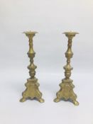 A PAIR OF ELABORATE HEAVY BRASS CANDLE STICKS.