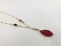 A VINTAGE YELLOW METAL PENDANT SET WITH A RED GLASS DROP (L42CM NOT INCLUDING DROP).