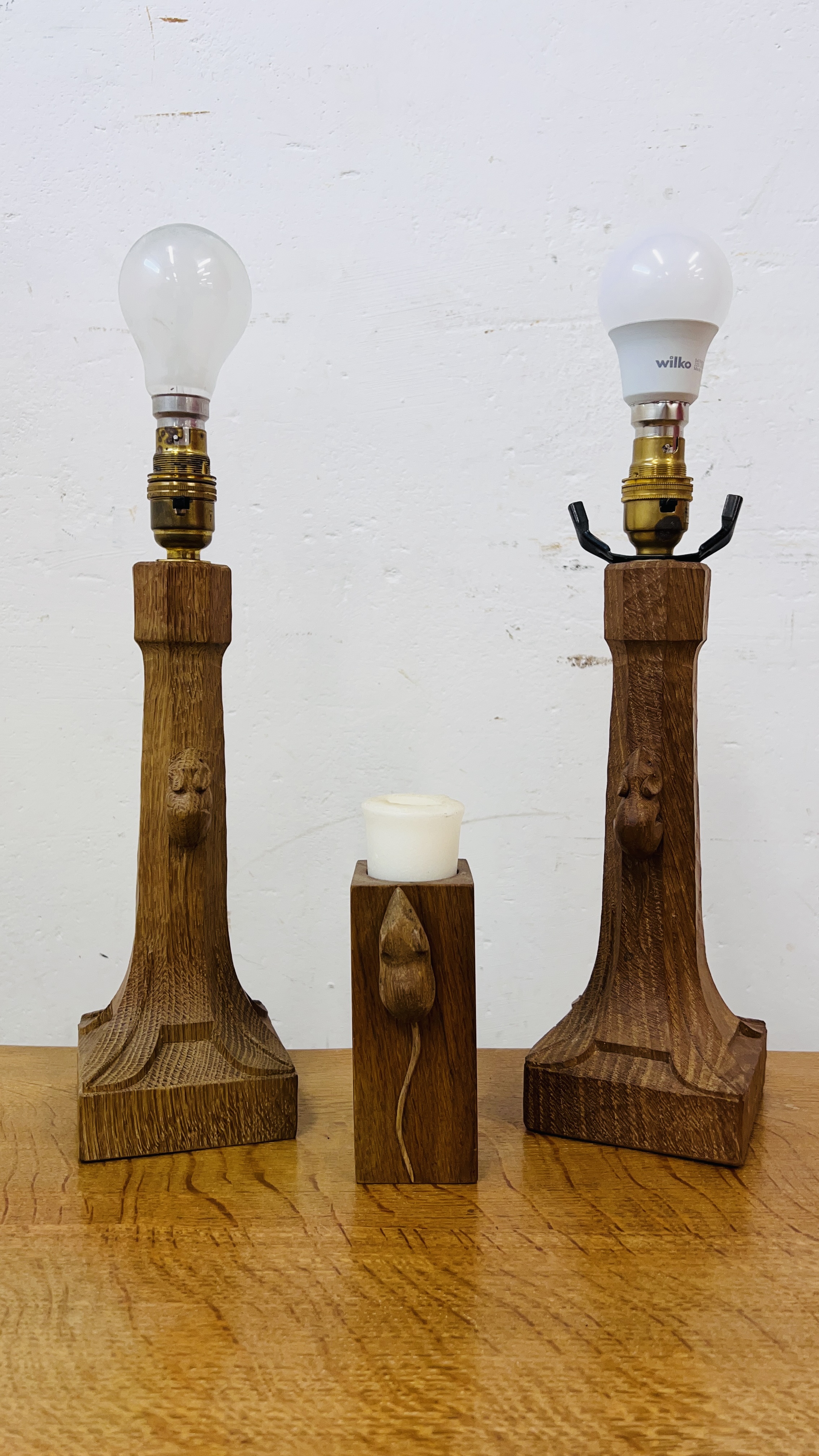 A PAIR OF ROBERT MOUSEMAN THOMPSON TABLE LAMPS HEIGHT 27CM ALONG WITH AN OAK CANDLE STICK WITH