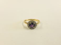 AN 18CT PLAT RING SET WITH CENTRAL PURPLE STONE SURROUNDED BY SMALL DIAMONDS.