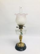 A VINTAGE BRASS OIL LAMP WITH CLEAR GLASS FONT AND GLASS SHADE ON A CIRCULAR BASE.