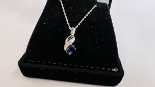 A 9CT WHITE GOLD PENDANT NECKLACE WITH CENTRAL BLUE STONE.