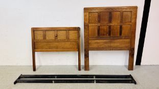 A ROBERT MOUSEMAN THOMPSON OAK SINGLE HEADBOARD WITH ASSOCIATED FOOT BOARD AND BED IRONS.