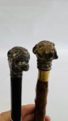 A VINTAGE STYLE BRASS DOG HEAD WALKING STICK AND A FURTHER SIMILAR WHITE METAL EXAMPLE.