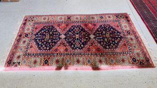 A MODERN PERSIAN RUG, THE THREE PRINCIPAL MOTIFS ON A PALE RED FIELD, 245CM LONG.