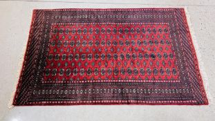 A MODERN TURKOMAN RUG, THE GULS ON A DARK RED FIELD IN A LATTICE DESIGN,