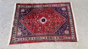 A MODERN PERSIAN RUG, THE CENTRAL STEPPED MOTIF ON A RED FIELD 150CM LONG. WIDTH 205CM.