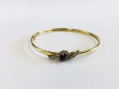 A 9CT BANGLE SET WITH A CENTRAL AMETHYST.