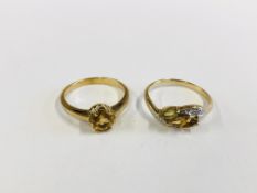 TWO 9CT GOLD RINGS SET WITH AMBER COLOURED STONES.