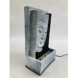 A RESIN LIGHT UP WATER FEATURE DEPICTING BUDDHA HEAD, W 27CM X H 48CM - SOLD AS SEEN.
