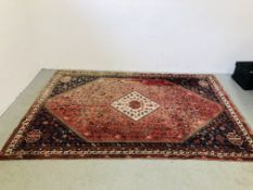 A LARGE PERSIAN RED AND BLUE PATTERNED RUG, THE CENTRAL MOTIF OF DIAMOND FORM HAVING ARROWS,