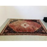 A LARGE PERSIAN RED AND BLUE PATTERNED RUG, THE CENTRAL MOTIF OF DIAMOND FORM HAVING ARROWS,