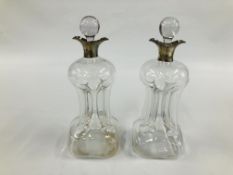 A PAIR OF ANTIQUE GLASS DECANTERS WITH SILVER RIMS,