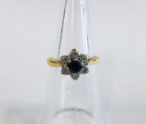 AN 18CT GOLD DIAMOND AND SAPPHIRE RING, IN A FLOWER HEAD SETTING.