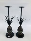 A PAIR OF MODERN DESIGNER PINEAPPLE FIGURED CANDLE STANDS - H 55.5CM ON CIRCULAR BASES.