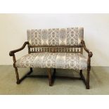 A VINTAGE OAK FRAMED UPHOLSTERED SETTLE HAVING TURNED DETAILING, W 123CM X D 54CM X H 92CM.