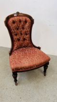 A VICTORIAN MAHOGANY FRAMED NURSING CHAIR WITH RED FLORAL UPHOLSTERY.