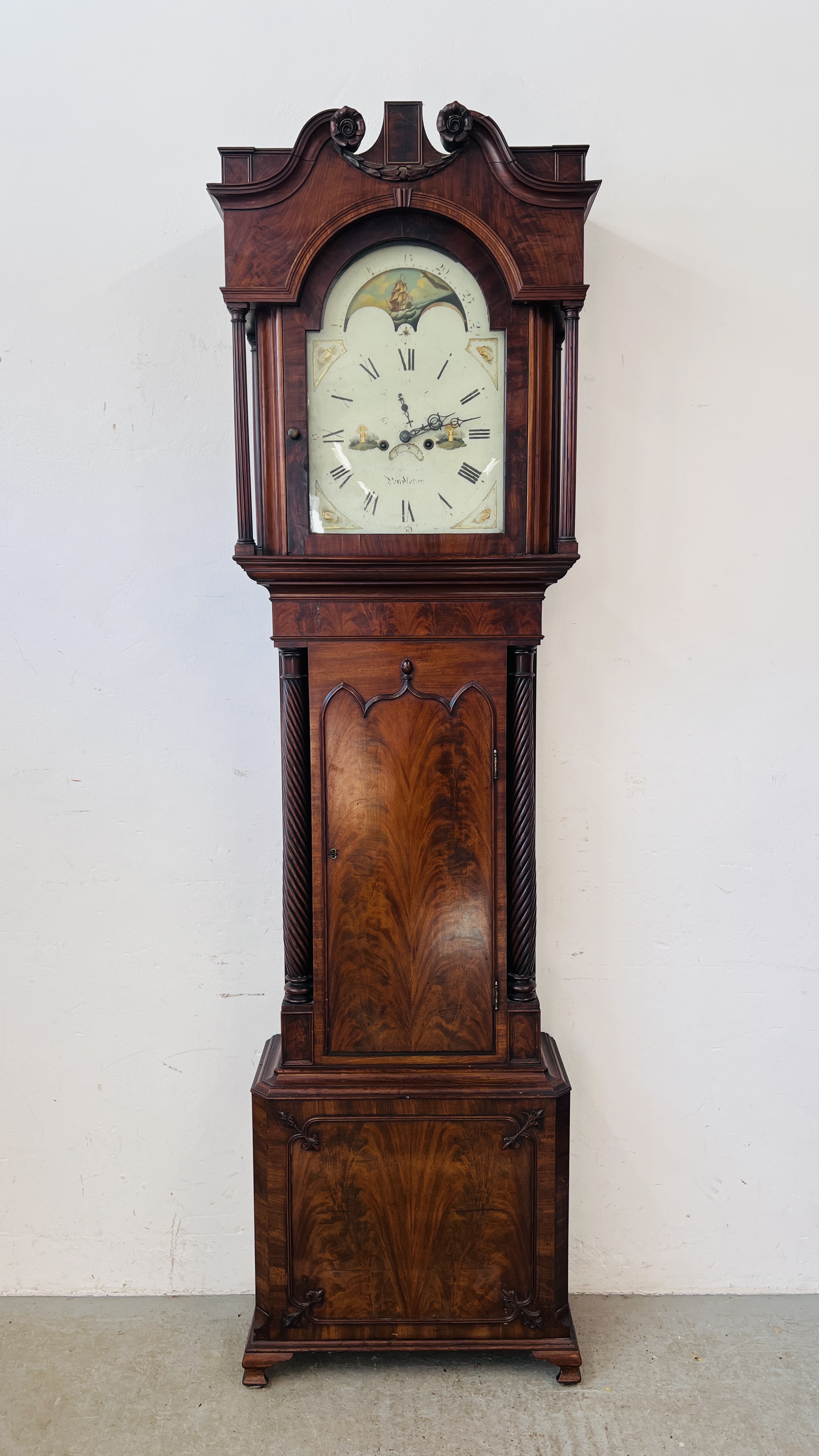 A MAHOGANY LONG CASE CLOCK ARCHED HAND PAINTED MOON PHASE DIAL.