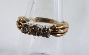 A 9CT GOLD THREE STONE DIAMOND RING.