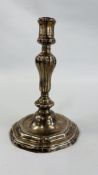 A CONTINENTAL CAST SILVER CANDLESTICK, THE GADROONED COLUMN ON A STEPPED AND SCROLLED BASE - 21.