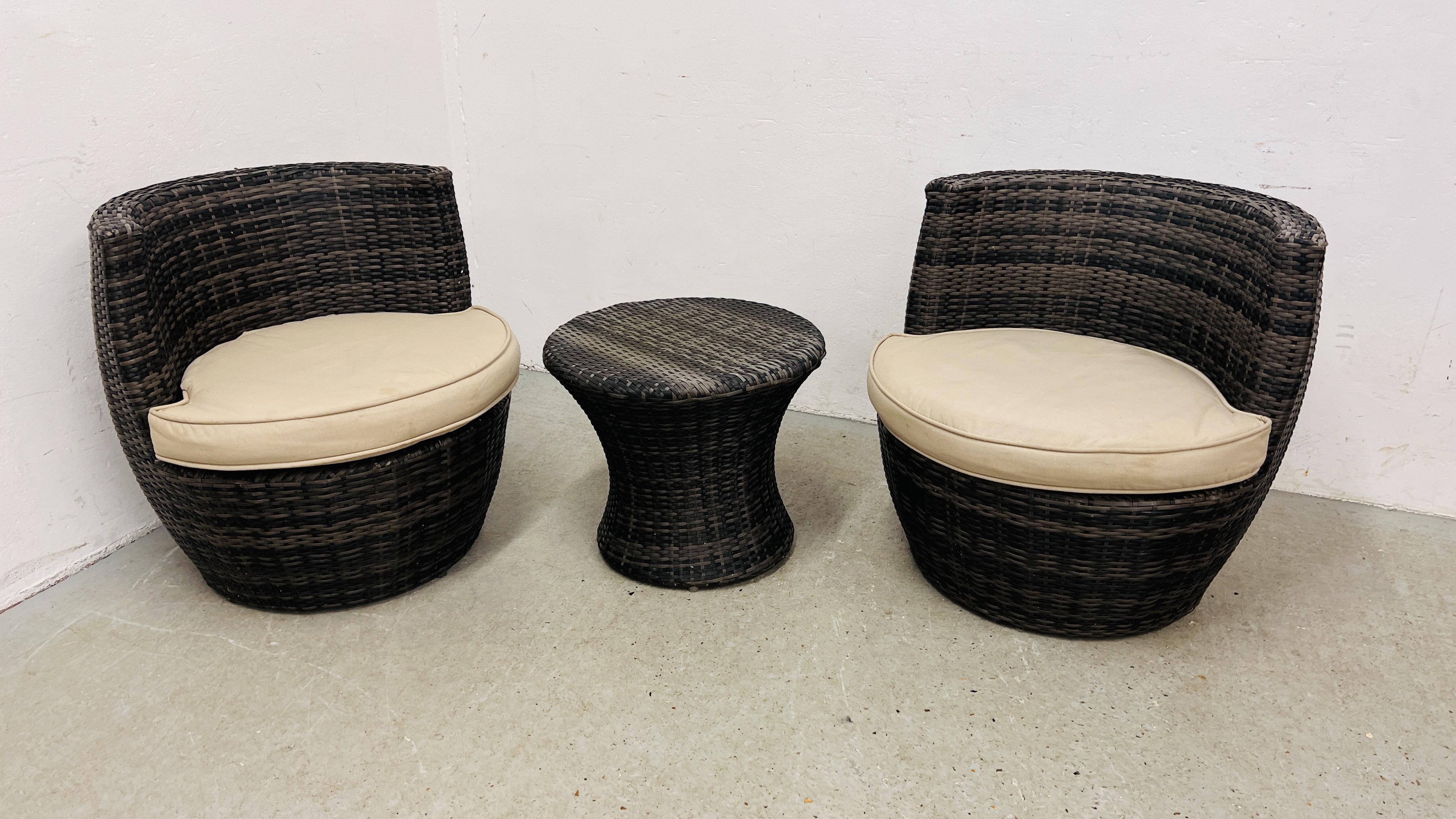 A PAIR OF MODERN GARDEN WOVEN BARREL CHAIRS ALONG WITH A MATCHING CIRCULAR TABLE.