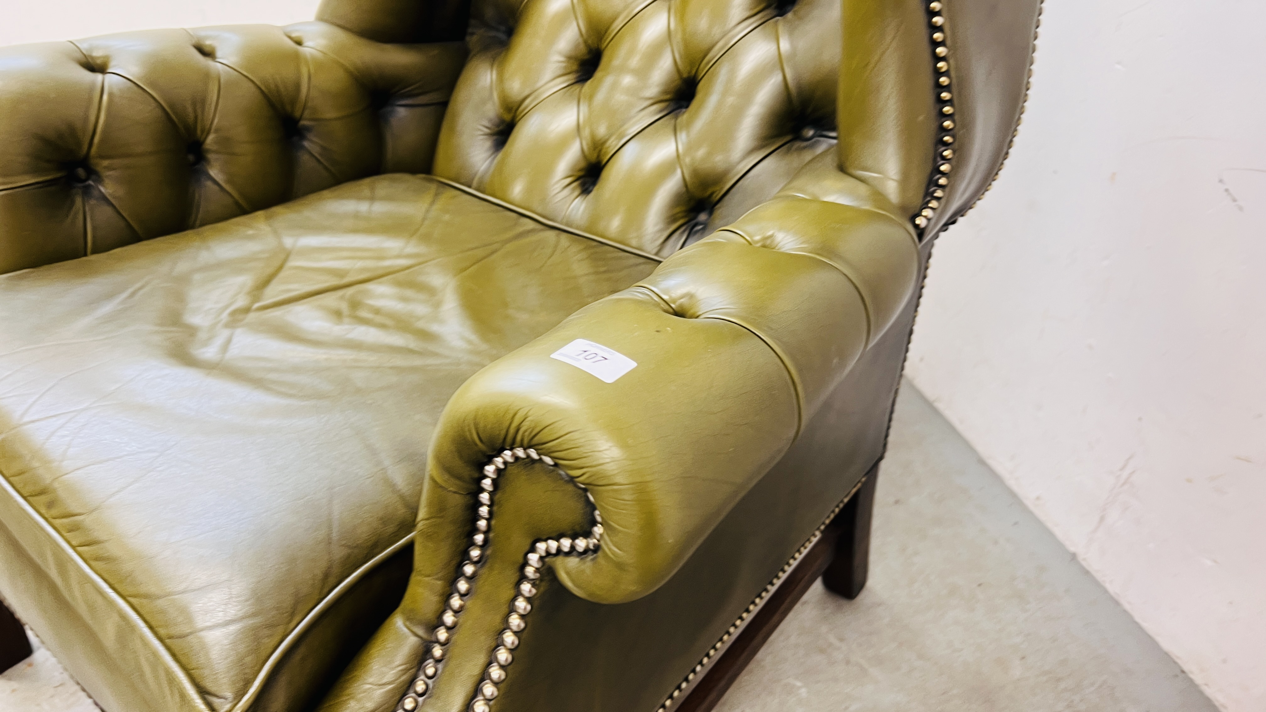 A PERIOD STYLE GREEN LEATHER BUTTON BACK FIRESIDE ARMCHAIR WITH STUD DETAIL. - Image 10 of 18