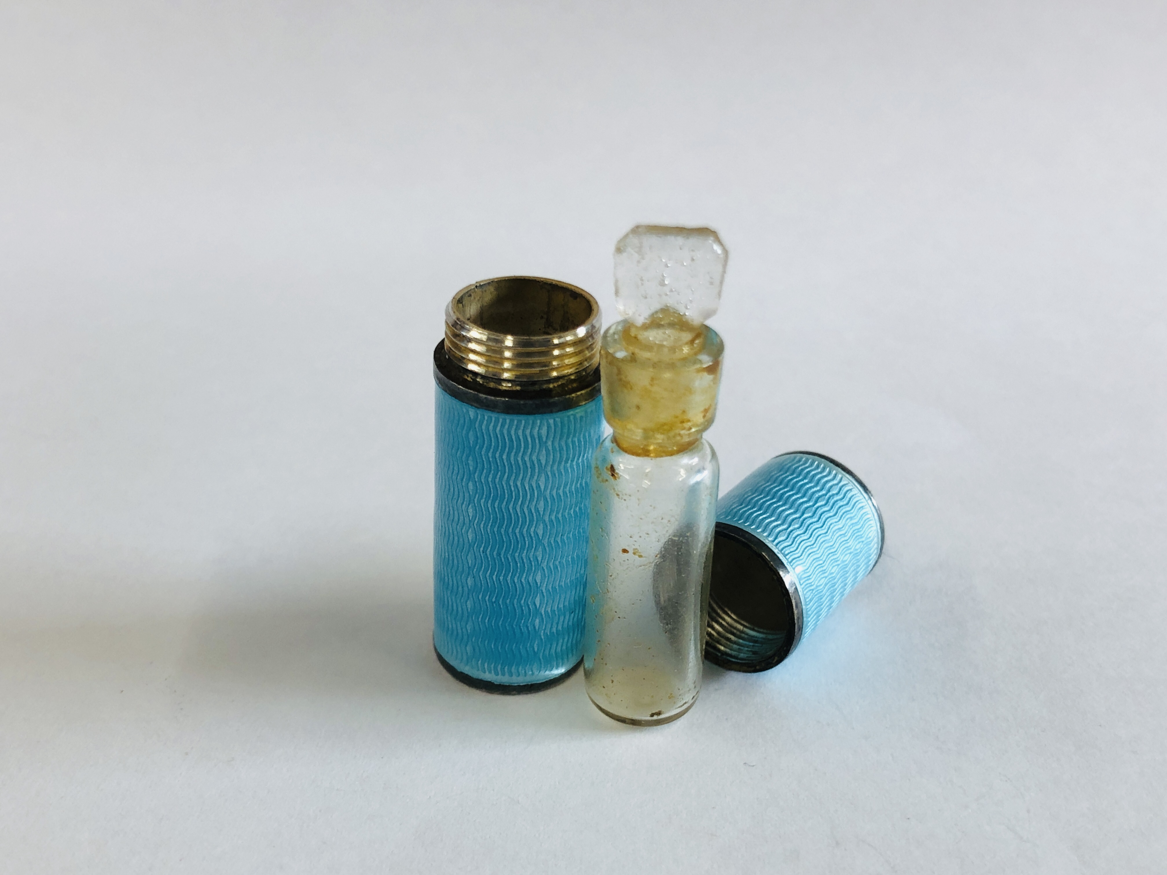 A VINTAGE ENAMELED SILVER CYLINDRICAL THREADED SCENT BOTTLE HOLDER CONTAINING A CLEAR GLASS SCENT - Image 5 of 7