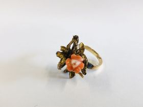 AN ELABORATE 14 KT GOLD RING INSET WITH A CORAL FLOWER.