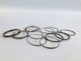 A GROUP OF SILVER AND WHITE METAL BANGLES.