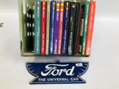 A GROUP OF 10 ASSORTED HAYNES MANUALS ALONG WITH A CAST REPRODUCTION FORD ADVERTISING SIGN.