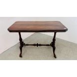 AN ANTIQUE MAHOGANY RECTANGULAR SIDE TABLE WITH TURNED STRETCHER BASE AND CASTER - W 105CM X 54CM.