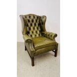 A PERIOD STYLE GREEN LEATHER BUTTON BACK FIRESIDE ARMCHAIR WITH STUD DETAIL.