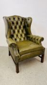 A PERIOD STYLE GREEN LEATHER BUTTON BACK FIRESIDE ARMCHAIR WITH STUD DETAIL.