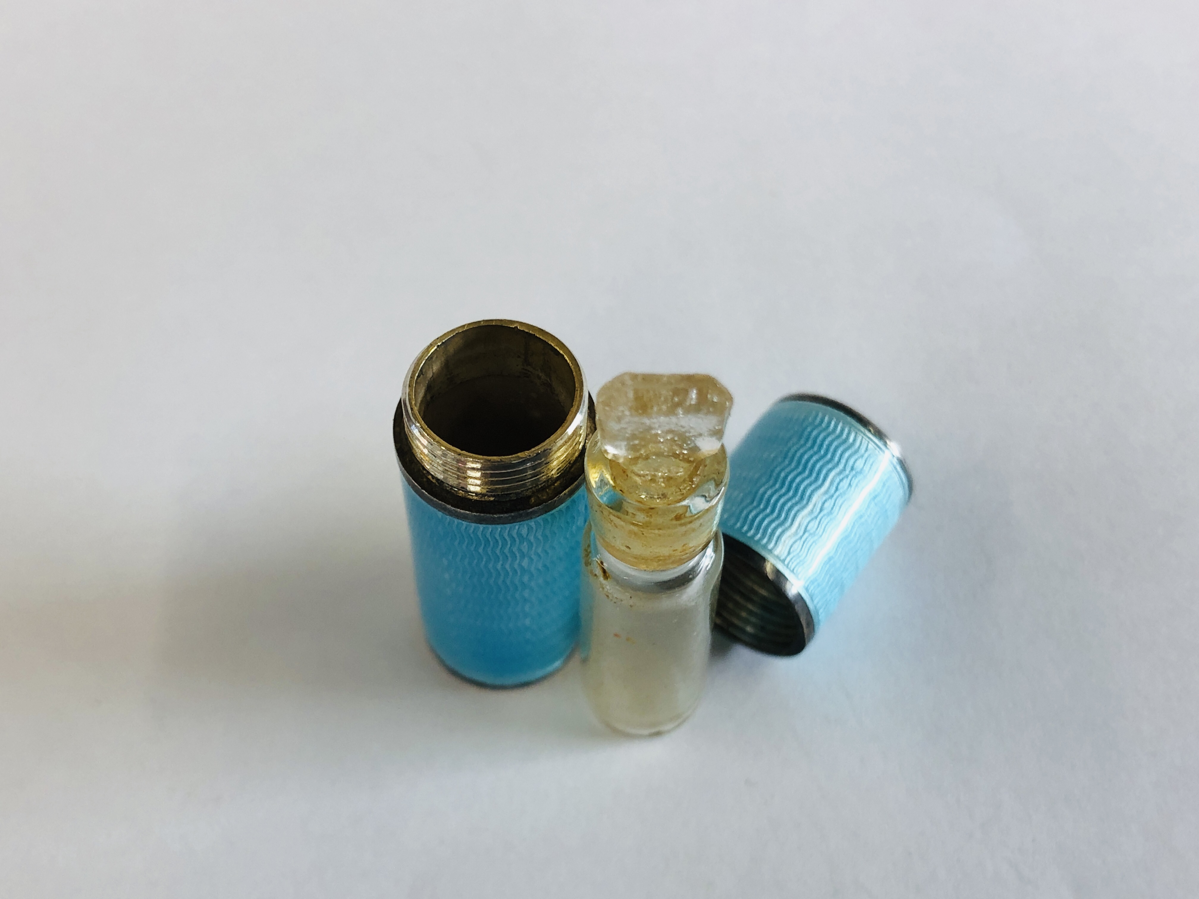 A VINTAGE ENAMELED SILVER CYLINDRICAL THREADED SCENT BOTTLE HOLDER CONTAINING A CLEAR GLASS SCENT - Image 6 of 7