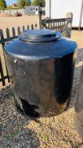 A LARGE BLACK PLASTIC WATER STORAGE TANK, H 130CM X D 110CM, WITH FLIP LID AND INLET AND OUTLET.