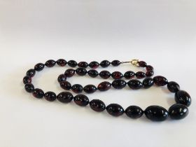 A STRING OF CHERRY AMBER TYPE BEADS, L 80CM.