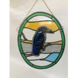 AN OVAL STAINED GLASS HANGING DEPICTING A KINGFISHER - H 42 X W 34CM.