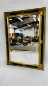 A MODERN GILT AND BLACK FRAMED WALL MIRROR WITH BEVELED EDGE W 66CM X H 93CM.