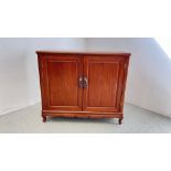 AN EASTERN MAHOGANY TWO DOOR CUPBOARD WITH TWO INTERNAL DRAWERS.