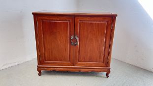 AN EASTERN MAHOGANY TWO DOOR CUPBOARD WITH TWO INTERNAL DRAWERS.